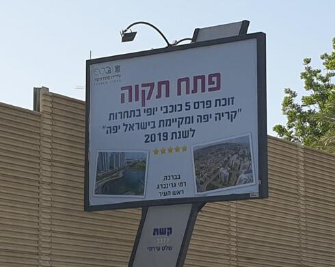 שלט חוצות עם שמו של רמי גרינברג